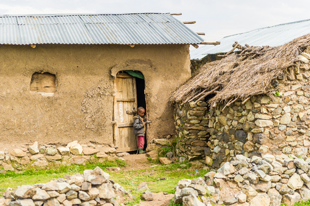 OMO, ETHIOPIA - SEPTEMBER 21, 2011: Unidentified Ethiopian boy near the house. People in Ethiopia suffer of poverty due to the unstable situationのeditorial素材