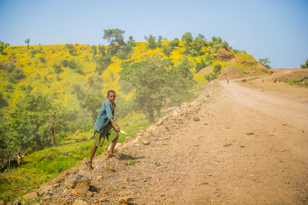 OMO, ETHIOPIA - SEPTEMBER 21, 2011: Unidentified Ethiopian boy runs on the road. People in Ethiopia suffer of poverty due to the unstable situationのeditorial素材