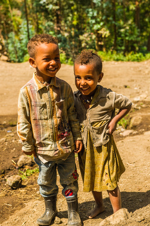 LALIBELA, ETHIOPIA - SEPTEMBER 28, 2011: Unidentified Ethiopian little friends play in the field. People in Ethiopia suffer of poverty due to the unstable situationのeditorial素材