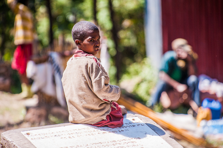 OMO, ETHIOPIA - SEPTEMBER 21, 2011: Unidentified Ethiopian boy on the stone. People in Ethiopia suffer of poverty due to the unstable situationのeditorial素材