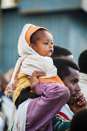 LALIBELA, ETHIOPIA - SEPTEMBER 28, 2011: Unidentified Ethiopian baby sits on his father's shoulders. People in Ethiopia suffer of poverty due to the unstable situationのeditorial素材