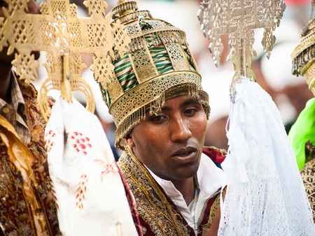 LALIBELA, ETHIOPIA - SEP 27, 2011: Unidentified Ethiopian religious man holds the golden cross and...