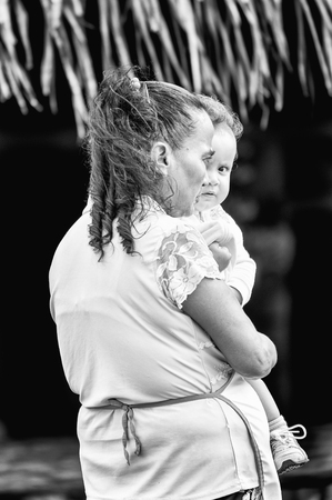 GUATEMALA CITY, GUATEMALA - JANUARY 1, 2012: Portrait of unidentified woman carring her child on her arms in Guatemala. 59.4% of Guatemala people belong to the Mestizo ethnic groupのeditorial素材