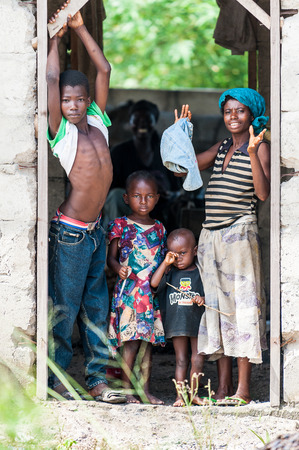 ACCRA, GHANA - MARCH 3, 2012: Unidentified Ghanaian children and their mother stay at the porch in Ghana. People of Ghana suffer of poverty due to the unstable economic situationのeditorial素材