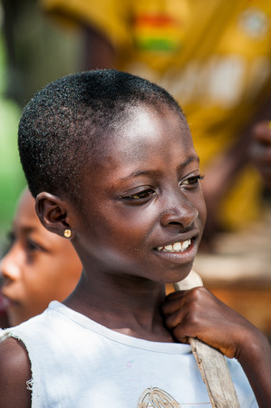 ACCRA, GHANA - MARCH 3, 2012: Unidentified Ghanaian girl smiles for the camera in Ghana. People of Ghana suffer of poverty due to the unstable economic situationのeditorial素材