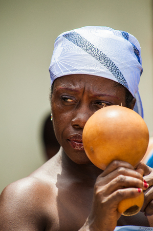 ACCRA, GHANA - MARCH 4, 2012: Unidentified Ghanaian woman sings a song at the local street music show in Ghana. Music is the main kind of entertainment in Africaのeditorial素材