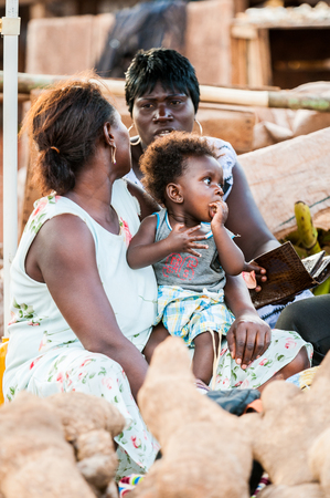 ACCRA, GHANA - MARCH 5, 2012: Unidentified Ghanaian baby boy on his mother arms in the street in Ghana. Children of Ghana suffer of poverty due to the unstable economic situationのeditorial素材