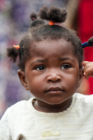 ACCRA, GHANA - MARCH 4, 2012: Unidentified Ghanaian girl in the street in Ghana. Children of Ghana suffer of poverty due to the unstable economic situationのeditorial素材