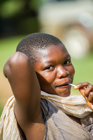 ACCRA, GHANA - MARCH 5, 2012: Unidentified Ghanaian woman with lollypop portrait in the street in Ghana. People of Ghana suffer of poverty due to the unstable economic situationのeditorial素材