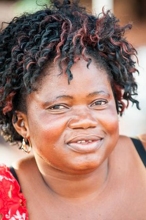ACCRA, GHANA - MARCH 4, 2012: Unidentified Ghanaian woman with black and red hair in the street in Ghana. People of Ghana suffer of poverty due to the unstable economic situationのeditorial素材