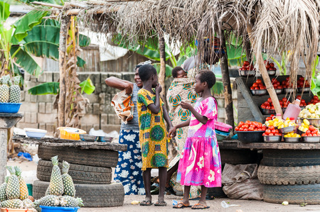 ACCRA, GHANA - MARCH 2, 2012: Unidentified Ghanaian two girls at the market in the street in Ghana. People of Ghana suffer of poverty due to the unstable economic situationのeditorial素材