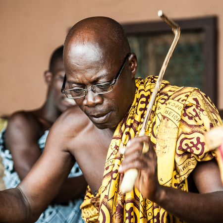 ACCRA, GHANA - MARCH 4, 2012: Unidentified Ghanaian man makes music for a local musical street show in Ghana. People of Ghana suffer of poverty due to the unstable economic situationのeditorial素材