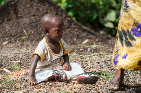 ACCRA, GHANA - MARCH 3, 2012: Unidentified Ghanaian girl sits on the ground in Ghana. People of Ghana suffer of poverty due to the unstable economic situationのeditorial素材
