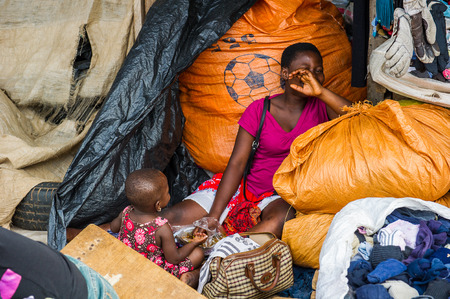 ACCRA, GHANA - MARCH 4, 2012: Unidentified Ghanaian woman and her child in Ghana. People of Ghana suffer of poverty due to the unstable economic situationのeditorial素材