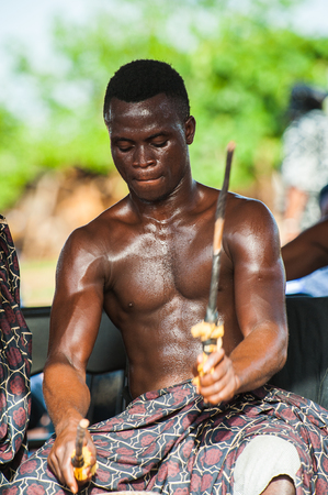 GHANA - MARCH 3, 2012: Unindentified Ghanaian local musician makes the traditional African sounds with the drum in Ghana, on March 3rd, 2012. Music is the main kind of entertainment in Africaのeditorial素材