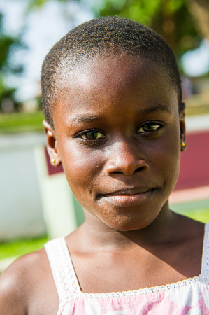 ACCRA, GHANA - MARCH 4, 2012: Unidentified Ghanaian beautiful girl portrait in the street in Ghana. People of Ghana suffer of poverty due to the unstable economic situationのeditorial素材