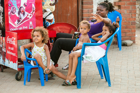 ACCRA, GHANA - MARCH 2, 2012: Unidentified Ghanaian children smile with their mother in Ghana. People of Ghana suffer of poverty due to the unstable economic situationのeditorial素材