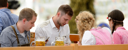 MUNICH, GERMANY - OCT 2, 2017: Unidentified friends drink beer at the Octoberfest,  the world's largest festivalのeditorial素材