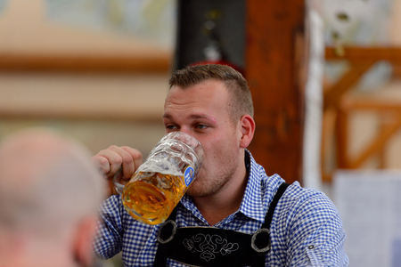 MUNICH, GERMANY - OCT 2, 2017: Unidentified man drinks beer at the Octoberfest,  the world's largest festivalのeditorial素材