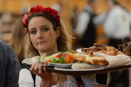MUNICH, GERMANY - OCT 2, 2017: Unidentified girl in traditional Bavarian costume works at the Octoberfest,  the world's largest festivalのeditorial素材