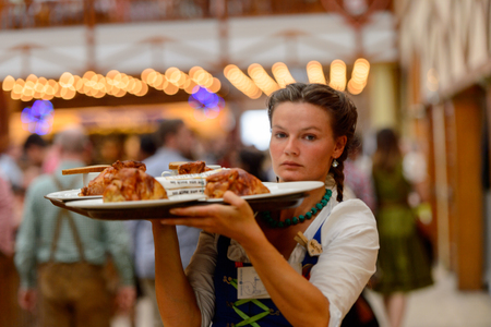MUNICH, GERMANY - OCT 2, 2017: Unidentified beautiful girl in traditional Bavarian costume works as a waitress at the Octoberfest,  the world's largest festivalのeditorial素材
