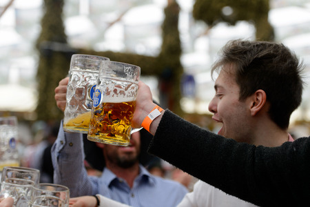 MUNICH, GERMANY - OCT 2, 2017: Unidentified young man drinks beer at the Octoberfest,  the world's largest festivalのeditorial素材