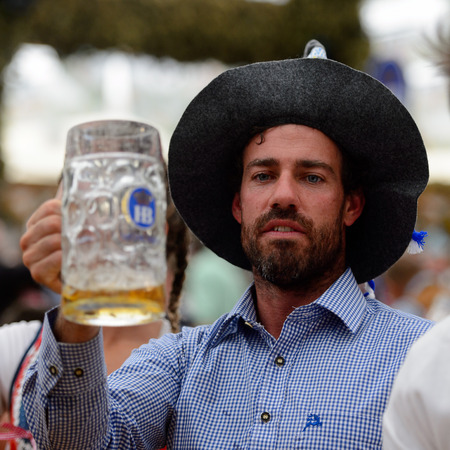 MUNICH, GERMANY - OCT 2, 2017: Unidentified young man drinks beer at the Octoberfest,  the world's largest festivalのeditorial素材