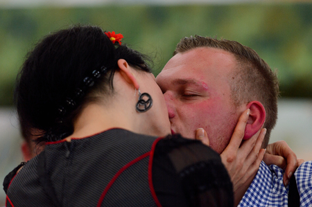 MUNICH, GERMANY - OCT 2, 2017: Unidentified girl in traditional Bavarian costume gives a kiss to a guy at the Octoberfest,  the world's largest festivalのeditorial素材