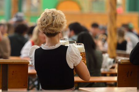 MUNICH, GERMANY - OCT 2, 2017: Unidentified woman in traditional Bavarian costume works as a waitress at the Octoberfest,  the world's largest festivalのeditorial素材
