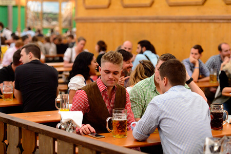 MUNICH, GERMANY - OCT 2, 2017: Unidentified friends drink beer at the Octoberfest,  the world's...