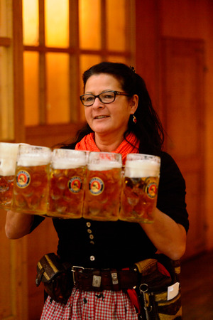 MUNICH, GERMANY - OCT 2, 2017: Unidentified woman in traditional Bavarian costume carries five glasses of beer at the Octoberfest,  the world's largest festivalのeditorial素材