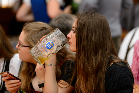 MUNICH, GERMANY - OCT 2, 2017: Unidentified beautiful girl drinks beer at the Octoberfest,  the world's largest festivalのeditorial素材