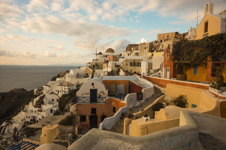 Image of white city on a slope of a hill at sunset and pink clouds, Oia, Santorini, Greeceの写真素材