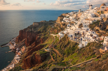Image of white city on a slope of a hill at sunset and pink clouds, Oia, Santorini, Greeceの写真素材