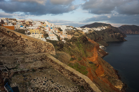 Image of white city on a slope of a hill at sunset and pink clouds, Oia, Santorini, Greeceの写真素材