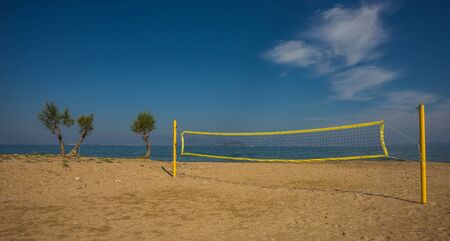 Volleyball tower, net and three trees on sandy beach near the town of Scala, Agistri, Greeceの写真素材