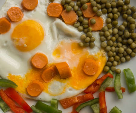 Fried eggs with sausages, green peas and bell pepper, Greeceの写真素材