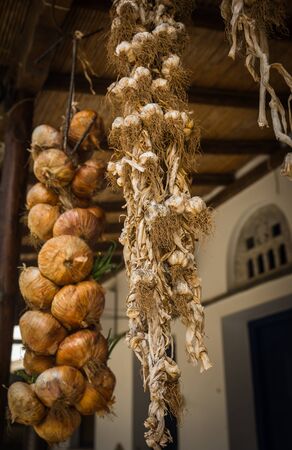 Braided bundles of onions and garlic on the island of Tinos, Greeceの写真素材