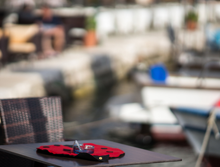 Table and cloth in the form of a ladybug on a blurred background of the city and port of Fiskardo at Kefalonia in Greeceの写真素材