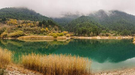 Autumn landscape with yellow leaves and green waters of lake Tsivlos, Peloponnese, Greece