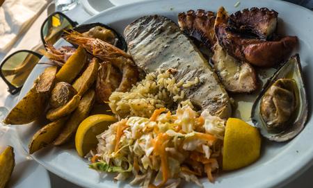 Image of mixed dish of fish and seafood on oval plate