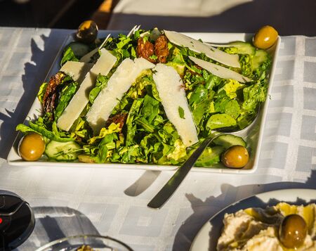 Image of arugula salad with parmesan cheese, dried tomatoes and olivesの写真素材
