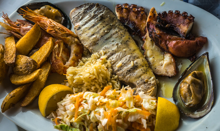 Image of mixed dish of fish and seafood on oval plate