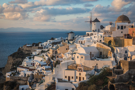 Image of white city on a slope of a hill at sunset, Oia, Santorini, Greeceの写真素材