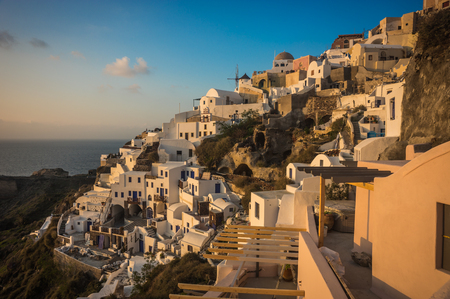 Image of white city on a slope of a hill at sunset, Oia, Santorini, Greeceの写真素材