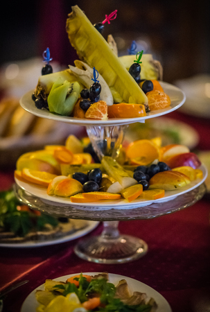 Image of Dishes with sliced fresh fruit on a festive tableの写真素材