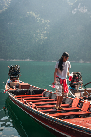 Chieou Laan lake, Thailand - January 11, 2011,  Guide on the lake in the boat at Chieou Laan lake, Thailandのeditorial素材
