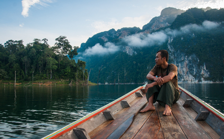 Chieou Laan lake, Thailand - January 12, 2011,  Guide on the lake in the boat at Chieou Laan lake, Thailandのeditorial素材