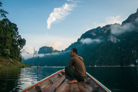 Chieou Laan lake, Thailand - January 12, 2011,  Guide on the lake in the boat at Chieou Laan lake, Thailandのeditorial素材
