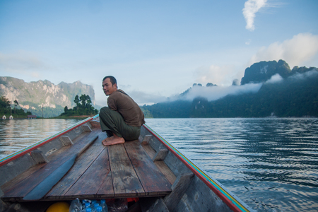 Chieou Laan lake, Thailand - January 12, 2011,  Guide on the lake in the boat at Chieou Laan lake, Thailandのeditorial素材